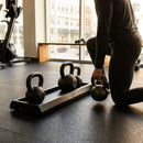 Black kettlebell stand with non-slip tray for gym use